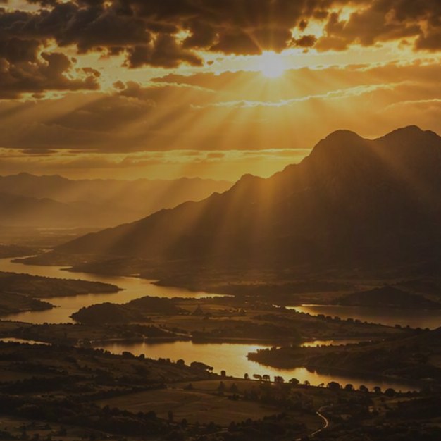 Golden light breaking over mountains and a river valley